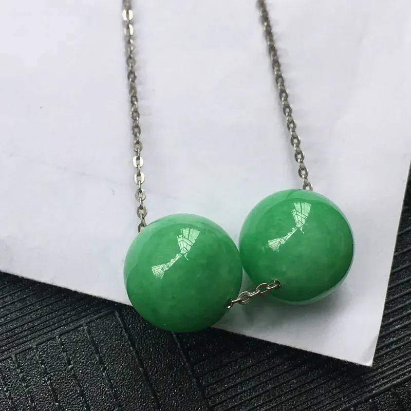 翡翠满绿圆珠镶件一对，种水好玉质细腻温润，颜色漂亮。尺寸：12.2mm 3.13克/12.3mm 3.21克（孔细链子仅当拍摄，当吊坠可绑绳子）