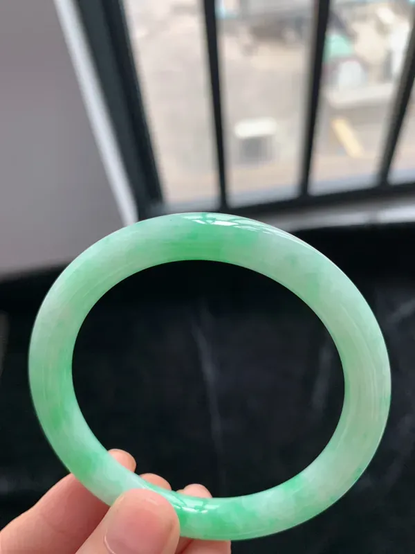 缅甸a货翡翠糯种带色圆条手镯54mm，玉质细腻，冰润透亮，花色清爽，条形大方得体，佩戴效果好