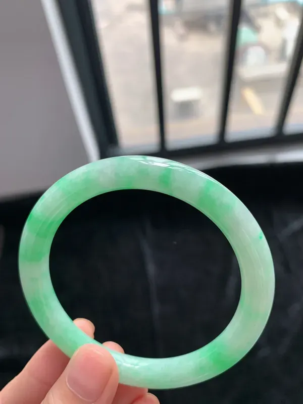 缅甸a货翡翠糯种带色圆条手镯54mm，玉质细腻，冰润透亮，花色清爽，条形大方得体，佩戴效果好