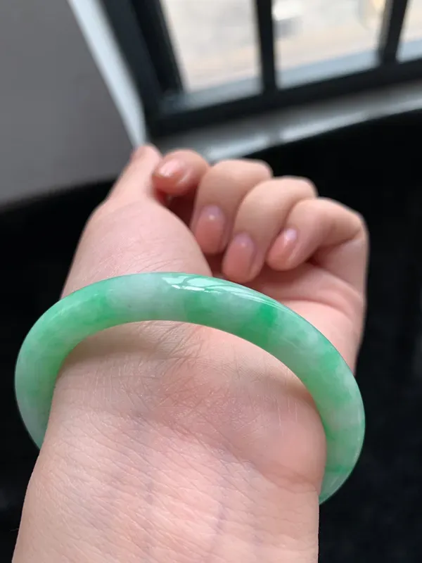 缅甸a货翡翠糯种带色圆条手镯54mm，玉质细腻，冰润透亮，花色清爽，条形大方得体，佩戴效果好