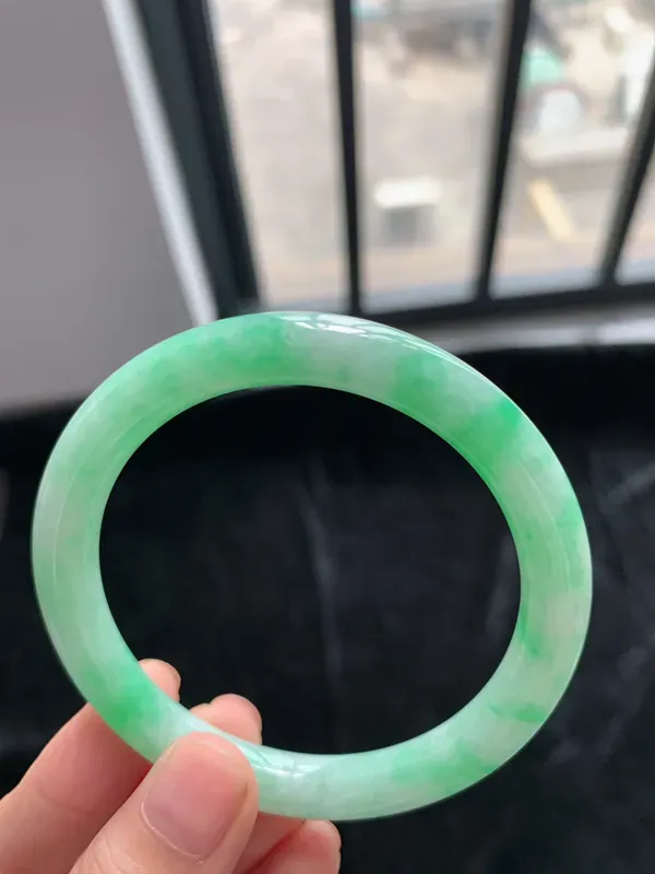 缅甸a货翡翠糯种带色圆条手镯54mm，玉质细腻，冰润透亮，花色清爽，条形大方得体，佩戴效果好