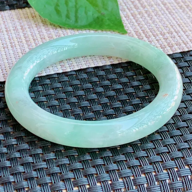 尺寸：54.3/10.3mm，天然Ａ货翡翠冰透带绿圆条手镯，玉质细腻冰润，种水好，上手效果更佳。