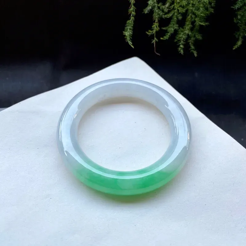 57-58圈口白底青圆条手镯，
尺寸:57.2×12.2×12mm，
底子细，质地干净，半圈阳绿鲜艳