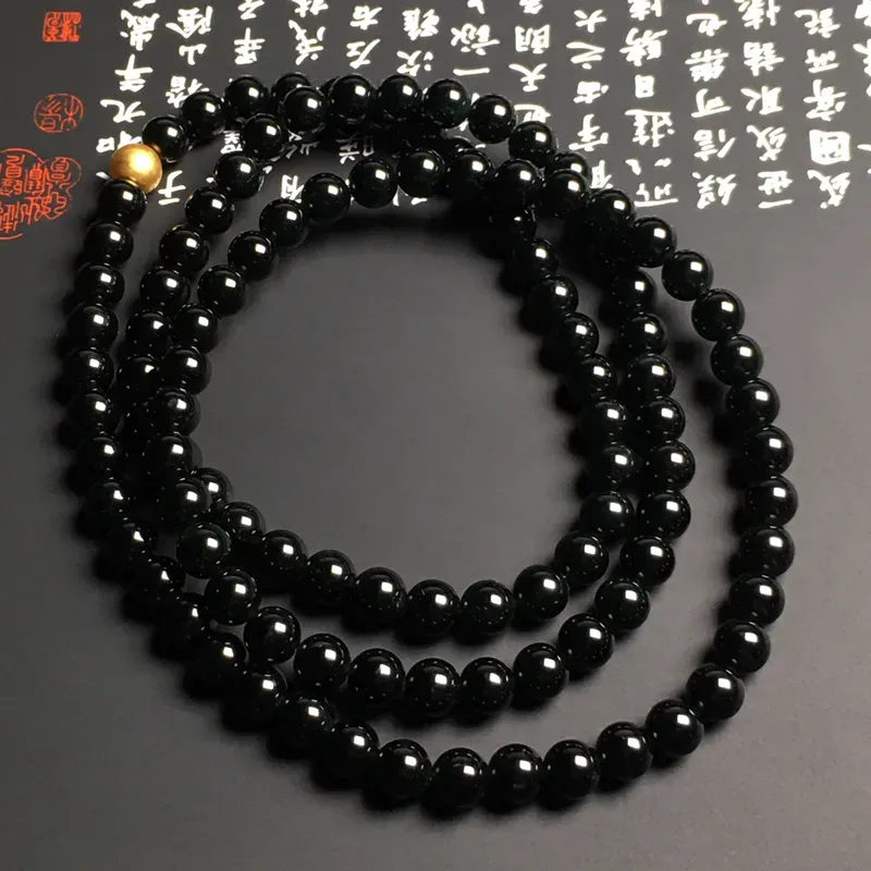 老坑冰种墨翠珠链 108颗 直径6.6毫米 黑度佳 款式时尚 打灯通透 翠色艳丽 质地细腻 金色配珠