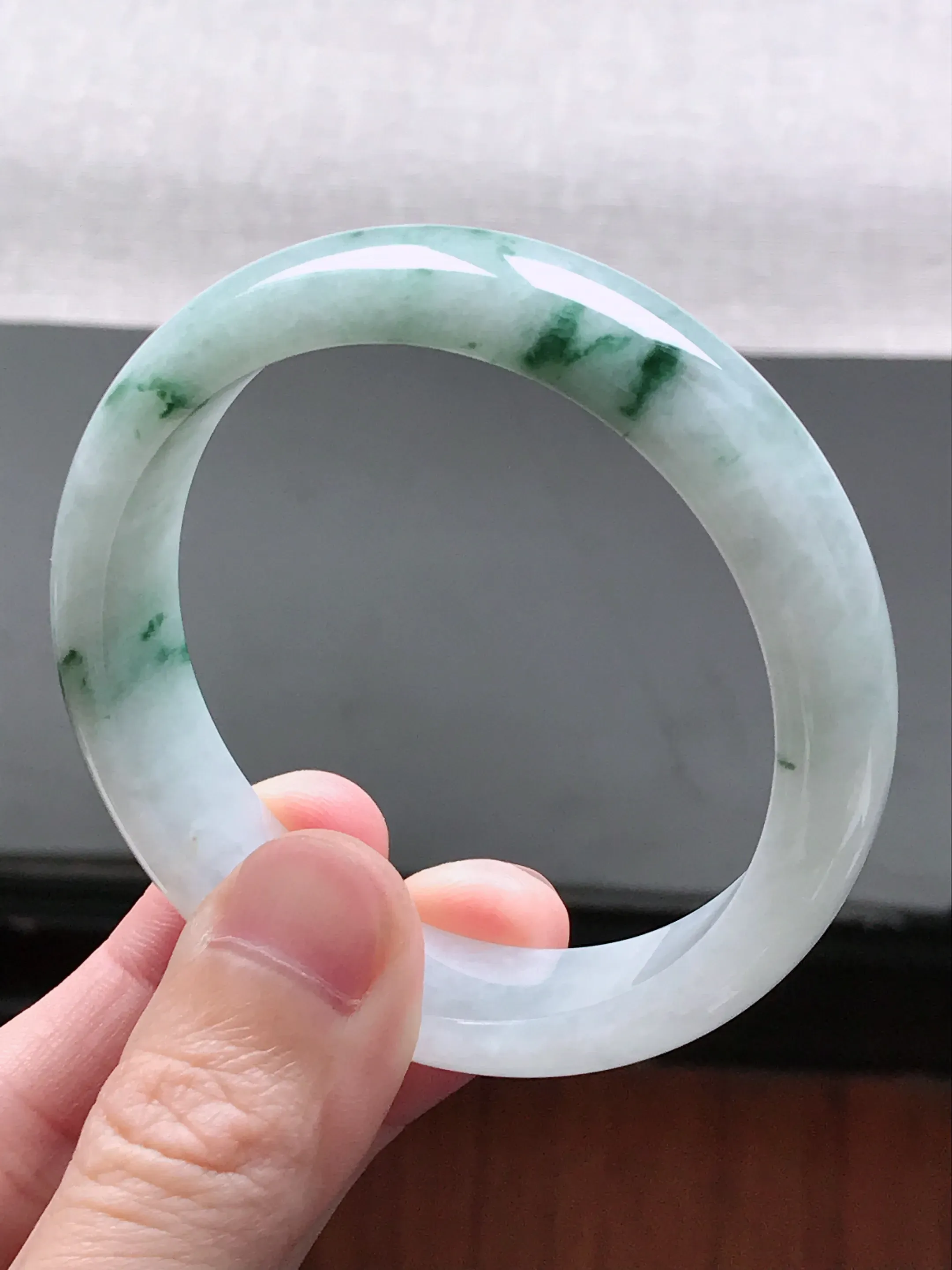 自然光实拍 圈口58-59  缅甸天然A货翡翠  冰润飘花宽边正装手镯  工艺细致  线条流畅精美  水头好  玉质细腻 尺寸：58.5*14.6*7.5mm 重量 :  62.40g