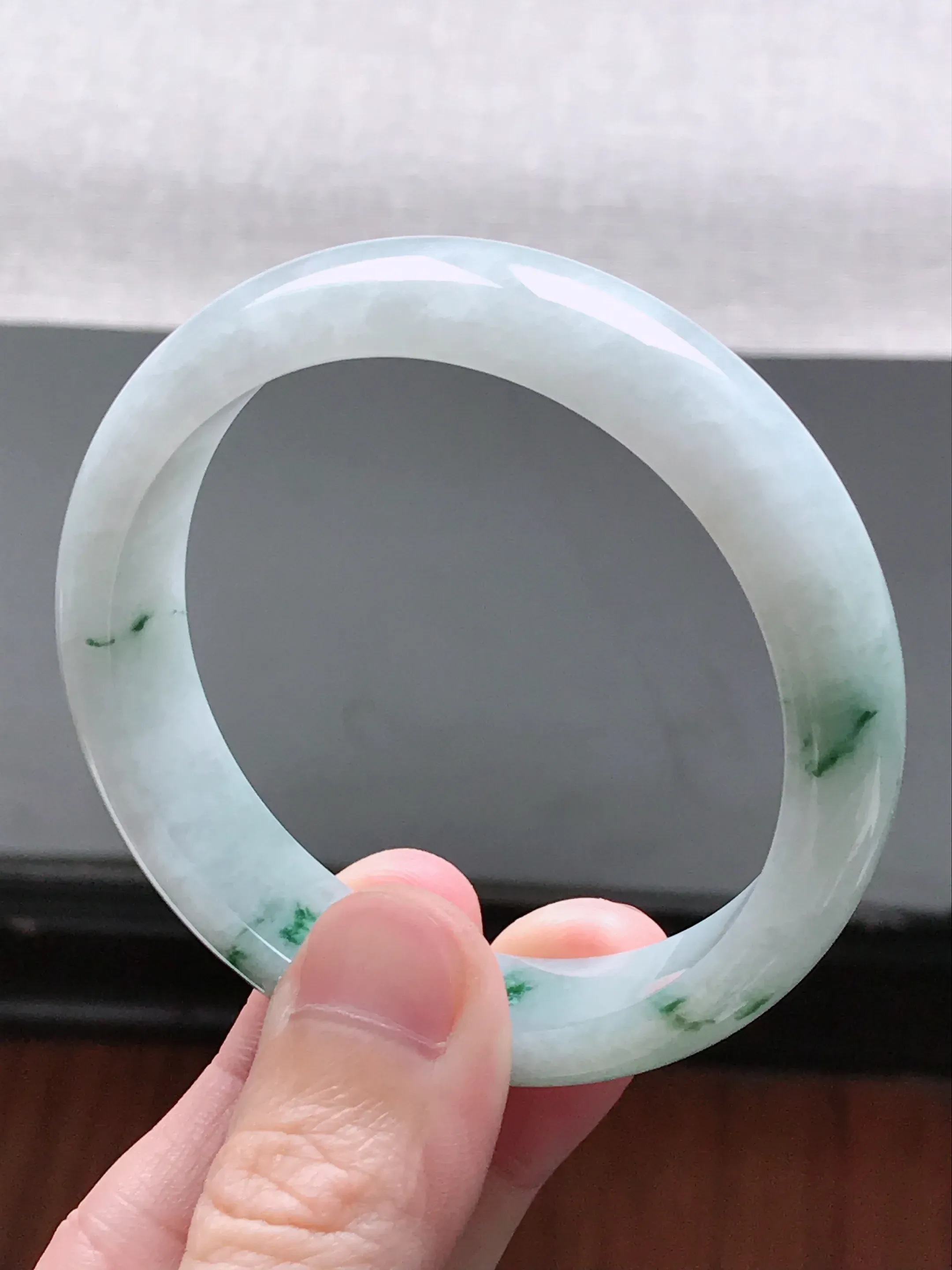 自然光实拍 圈口58-59  缅甸天然A货翡翠  冰润飘花宽边正装手镯  工艺细致  线条流畅精美  水头好  玉质细腻 尺寸：58.5*14.6*7.5mm 重量 :  62.40g