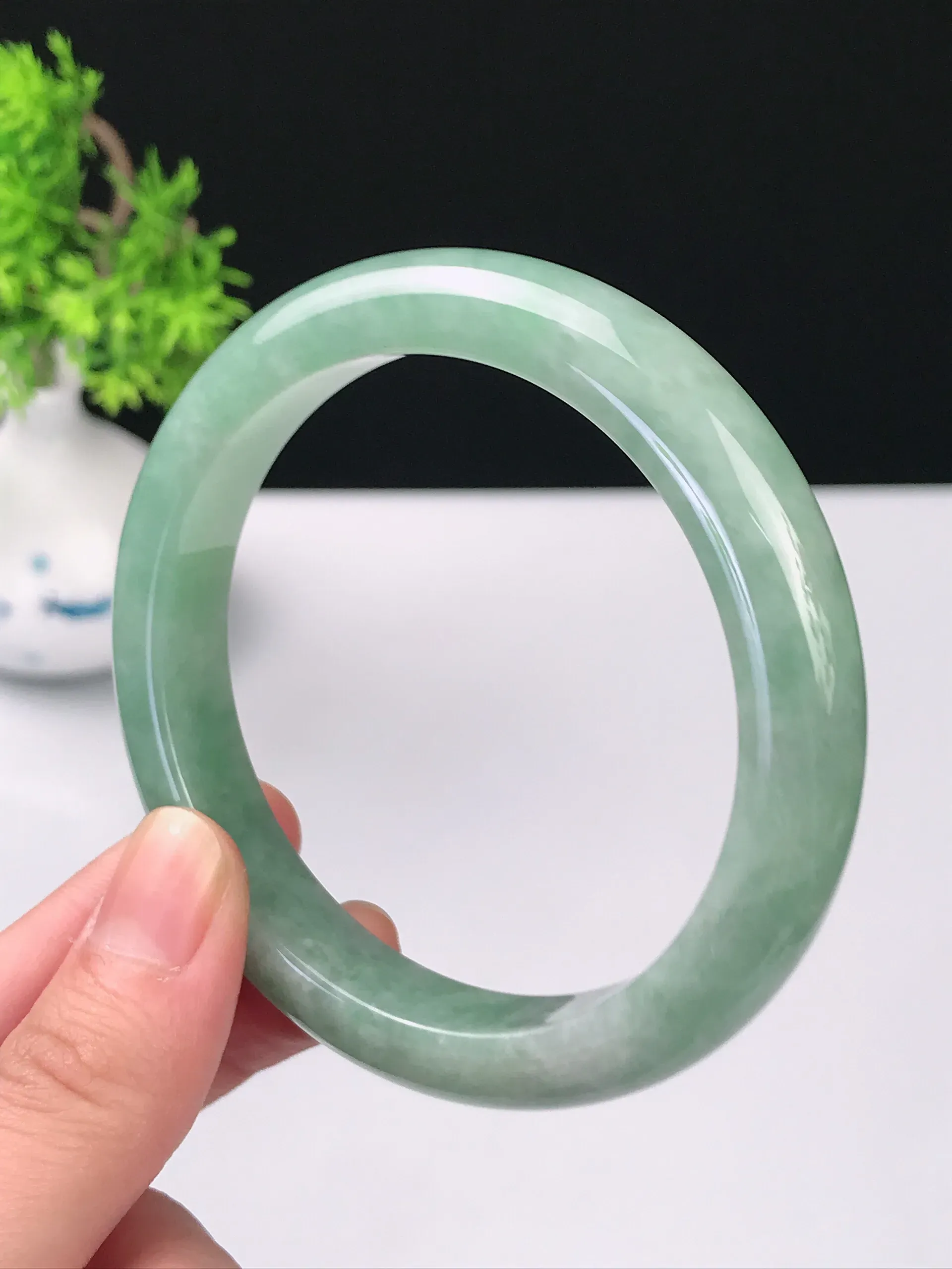 56-57圈口天然A货翡翠 老坑种冰润淡绿宽边手镯 尺寸：56.7*10.7*8.2mm 重量：50.52g 种好水足 雕工精致 佩戴效果佳