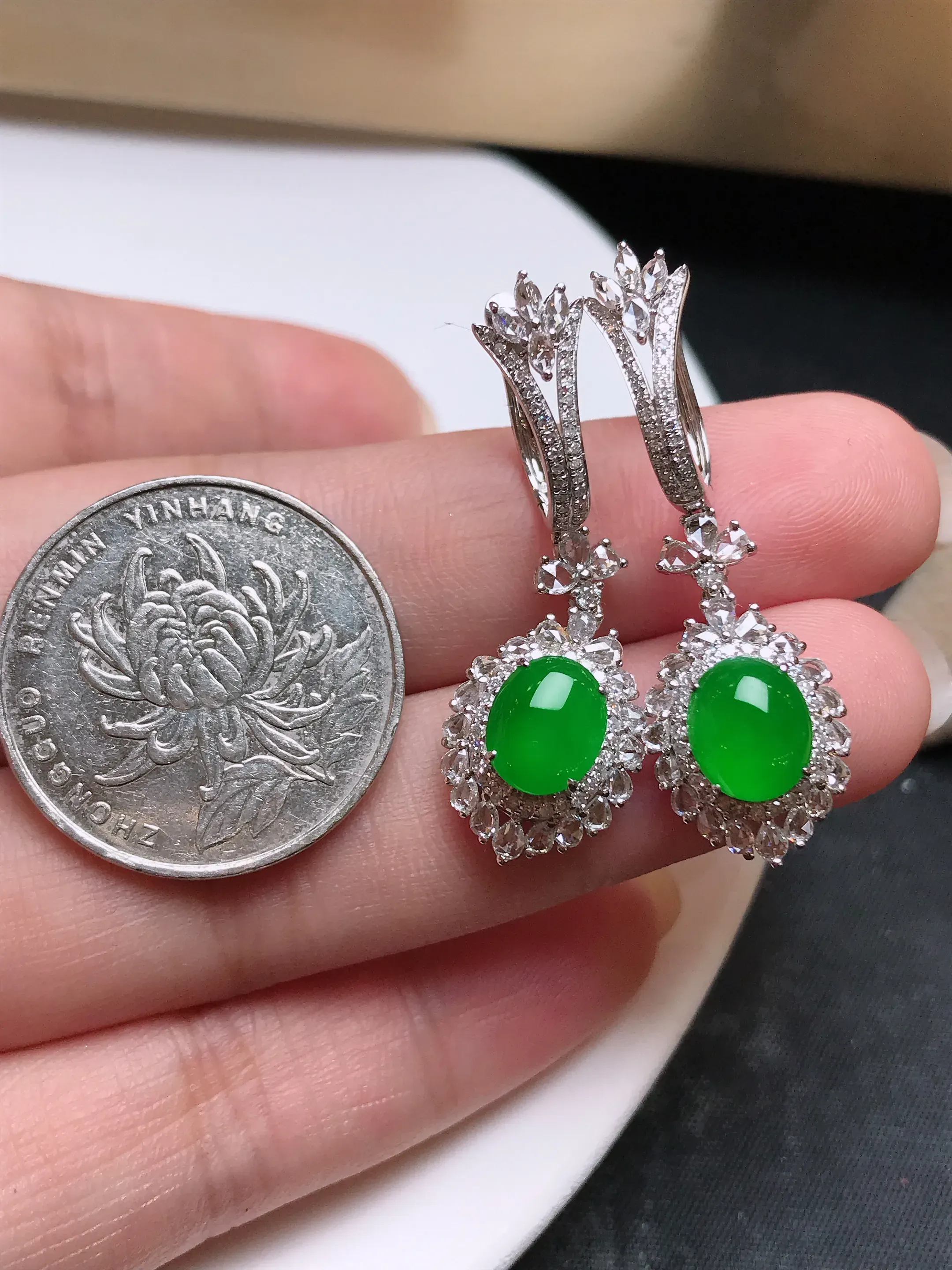 严选推荐 耳坠，老坑玻璃种翡翠满色绿蛋面耳坠，18k金钻精致镶嵌而成，品相佳，佩戴效果佳。种水上乘，冰感十足，盈润通透，起强玻璃光泽。高性价比，值得入手。裸石规格约8.4-6.9毫米