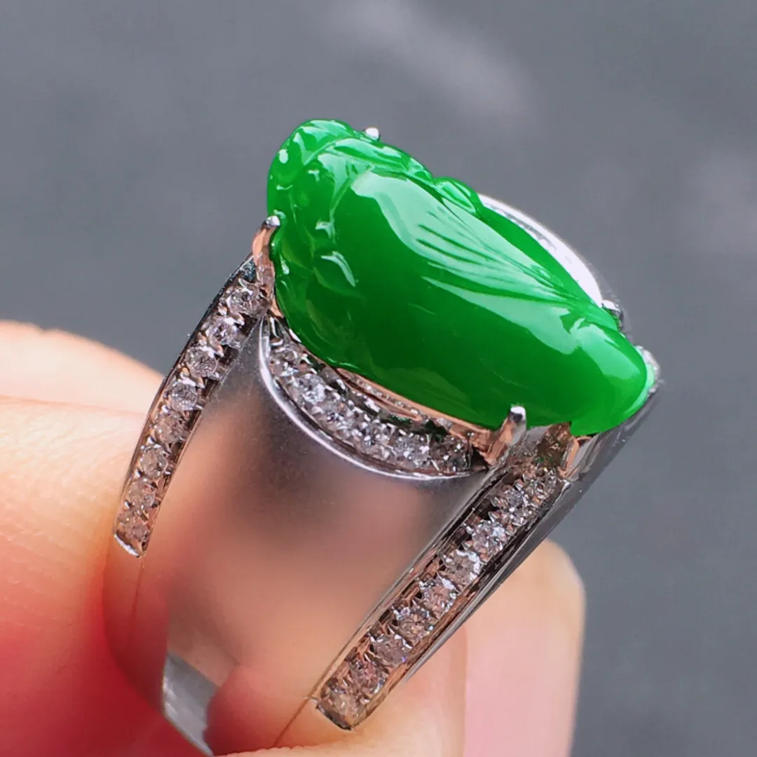 冰阳绿貔貅戒指，翠色明媚娇艳，荧光感超
强，饱满水润，上手很抢眼，气质满满。18k
金豪华镶嵌