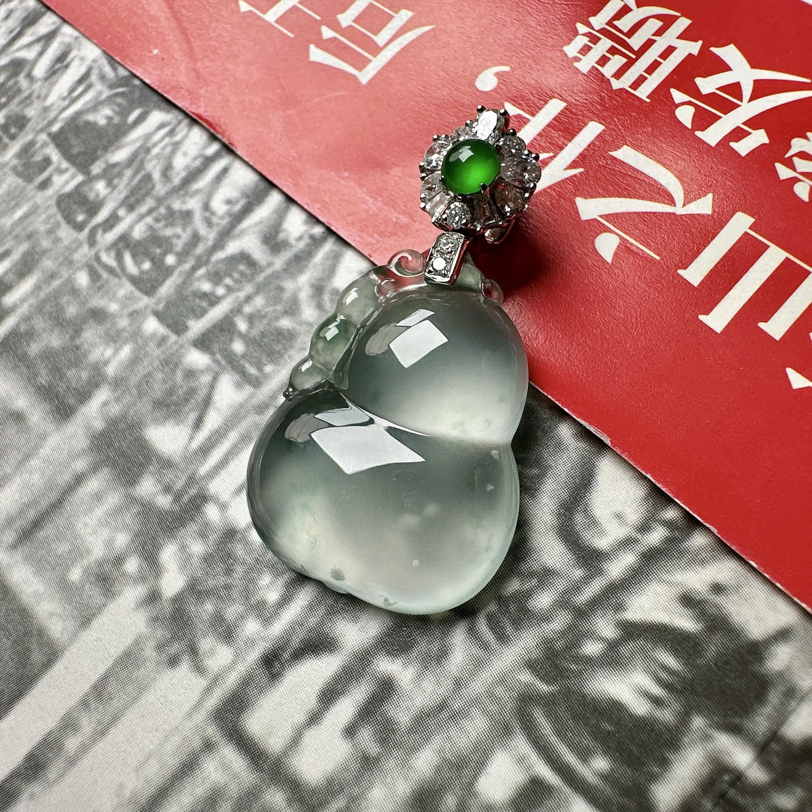 玻璃种飘花葫芦，晶莹剔透，光泽闪耀，飘了点淡蓝花，透手透字不在话下，裸石高度24.2毫米。