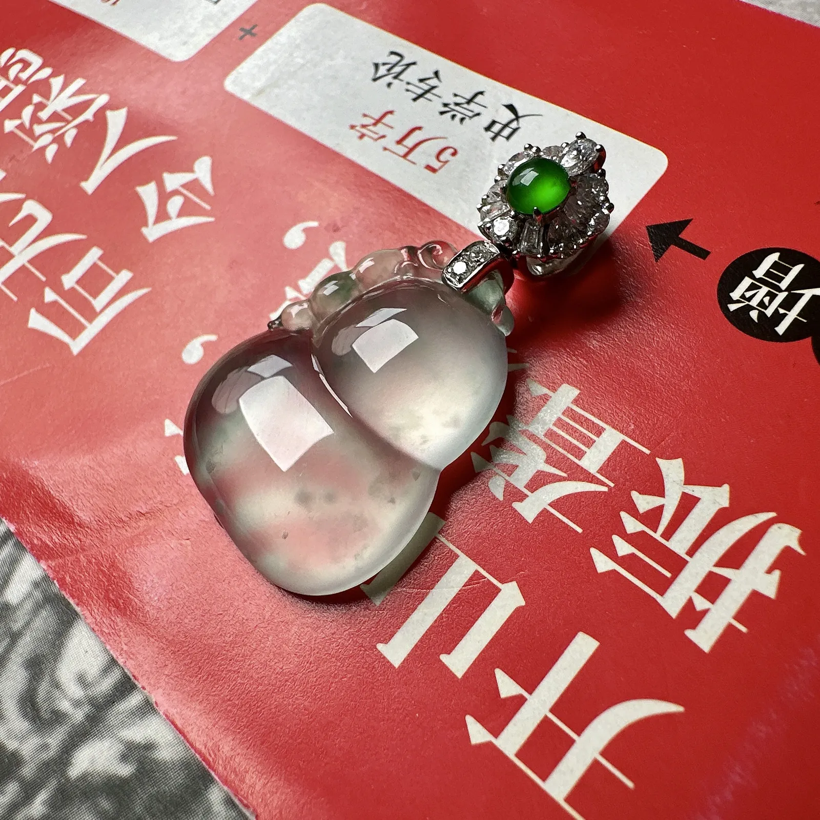 玻璃种飘花葫芦，晶莹剔透，光泽闪耀，飘了点淡蓝花，透手透字不在话下，裸石高度24.2毫米。