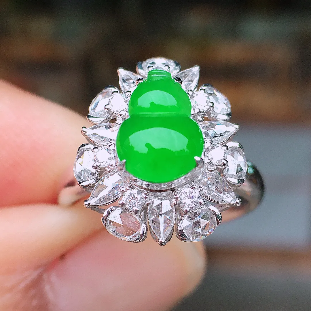 阳绿葫芦戒指，色泽均匀艳丽，玉质细腻，荧光感超
强，饱满水润，气质满满。18k
金豪华镶嵌