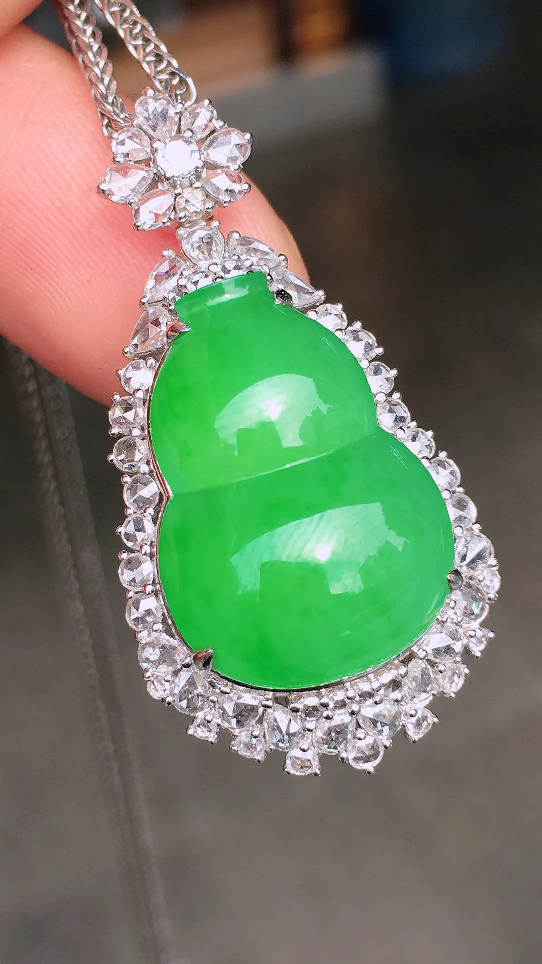 阳绿葫芦吊坠，色泽均匀艳丽，玉质细腻，荧光感超
强，饱满水润，气质满满。18k
金豪华镶嵌