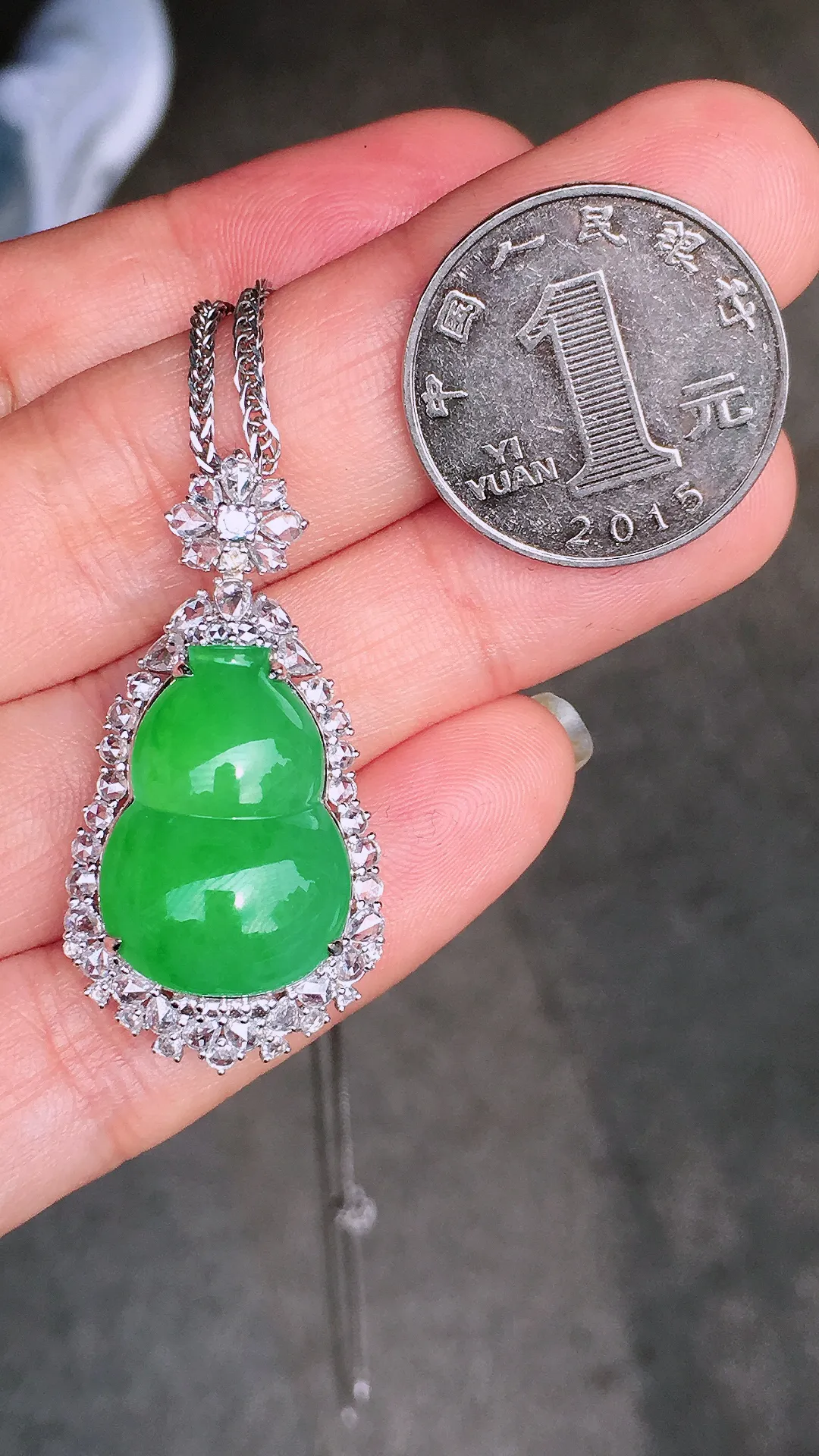 阳绿葫芦吊坠，色泽均匀艳丽，玉质细腻，荧光感超
强，饱满水润，气质满满。18k
金豪华镶嵌