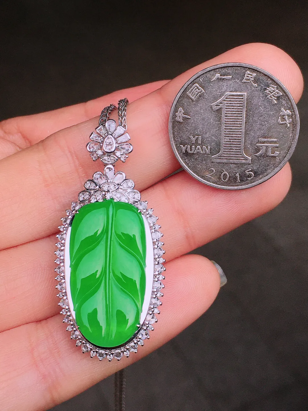 阳绿玉叶吊坠，色泽均匀艳丽，玉质细腻，荧光感超
强，饱满水润，气质满满。18k
金豪华镶嵌