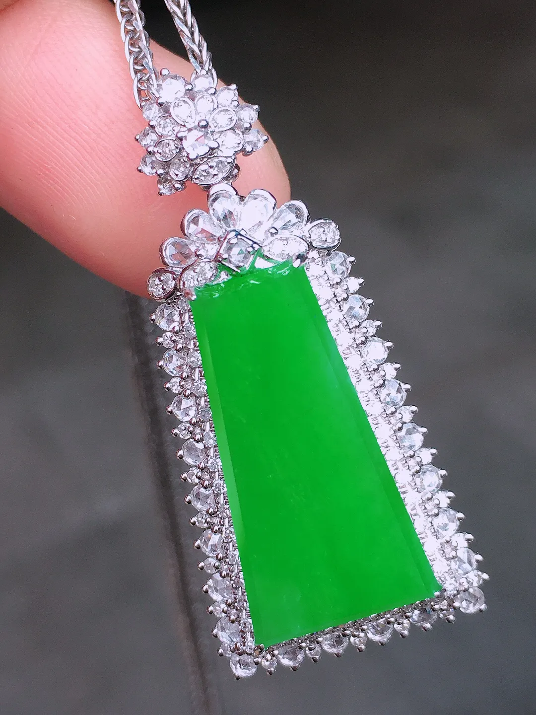 正阳绿无事牌吊坠，色泽均匀艳丽，玉质细腻，荧光感超
强，饱满水润，气质满满。18k
金豪华镶嵌