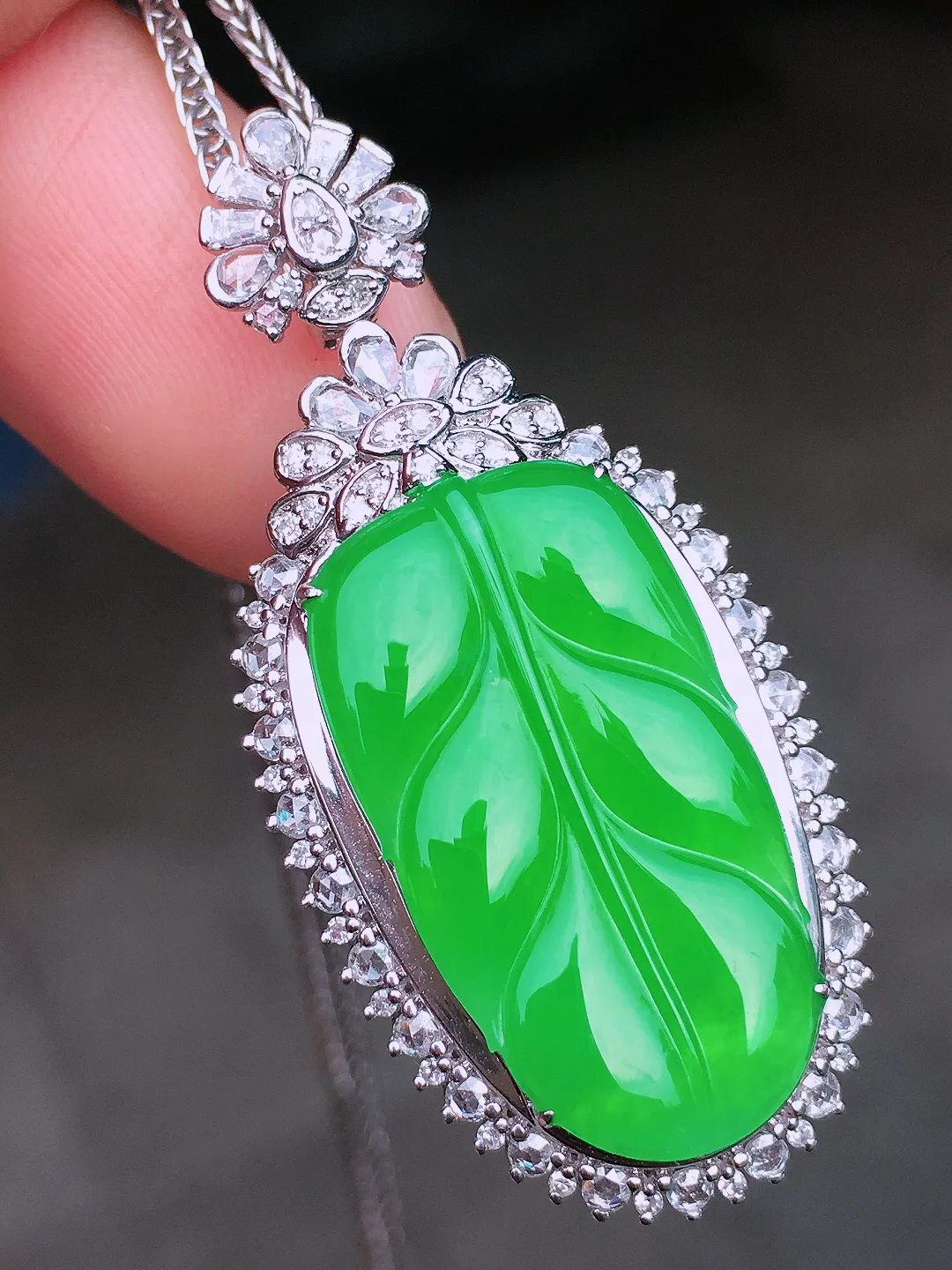 阳绿玉叶吊坠，色泽均匀艳丽，玉质细腻，荧光感超
强，饱满水润，气质满满。18k
金豪华镶嵌