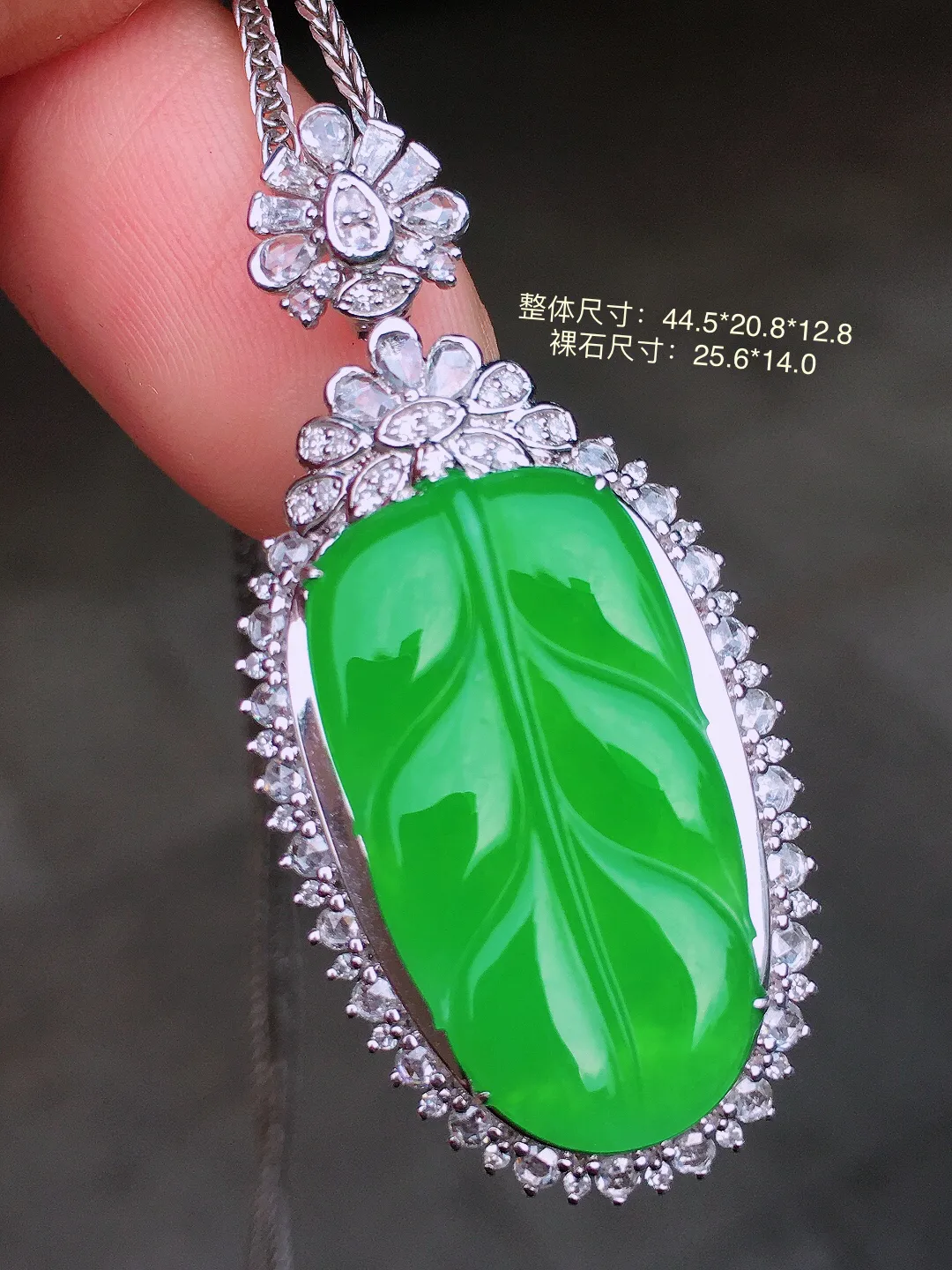 阳绿玉叶吊坠，色泽均匀艳丽，玉质细腻，荧光感超
强，饱满水润，气质满满。18k
金豪华镶嵌