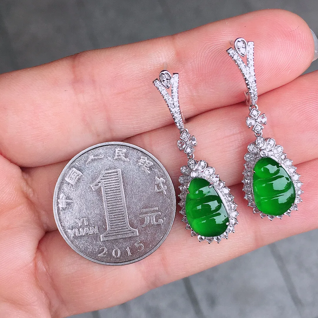 阳绿福豆耳坠，色泽均匀艳丽，玉质细腻，荧光感超
强，饱满水润，气质满满。18k
金豪华镶嵌