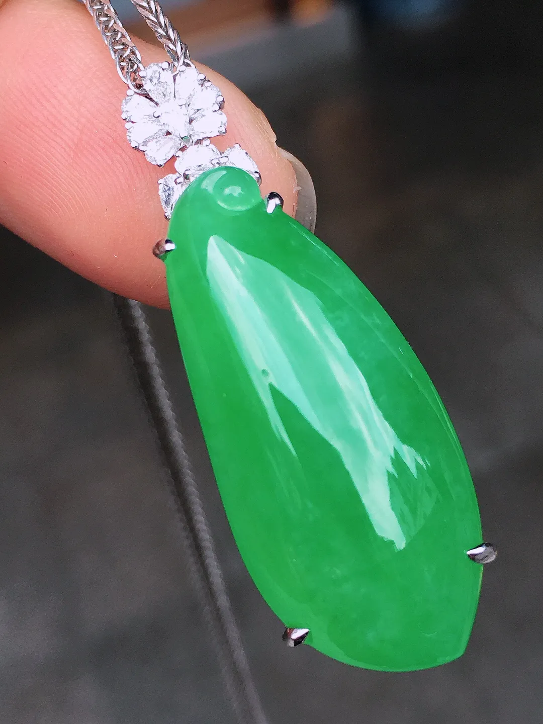 阳绿福瓜吊坠，色泽均匀艳丽，玉质细腻，荧光感超
强，饱满水润，气质满满。18k
金豪华镶嵌