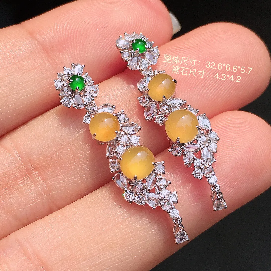 黄翡蛋面耳坠，色泽均匀艳丽，玉质细腻，荧光感超
强，饱满水润，气质满满。18k
金豪华镶嵌