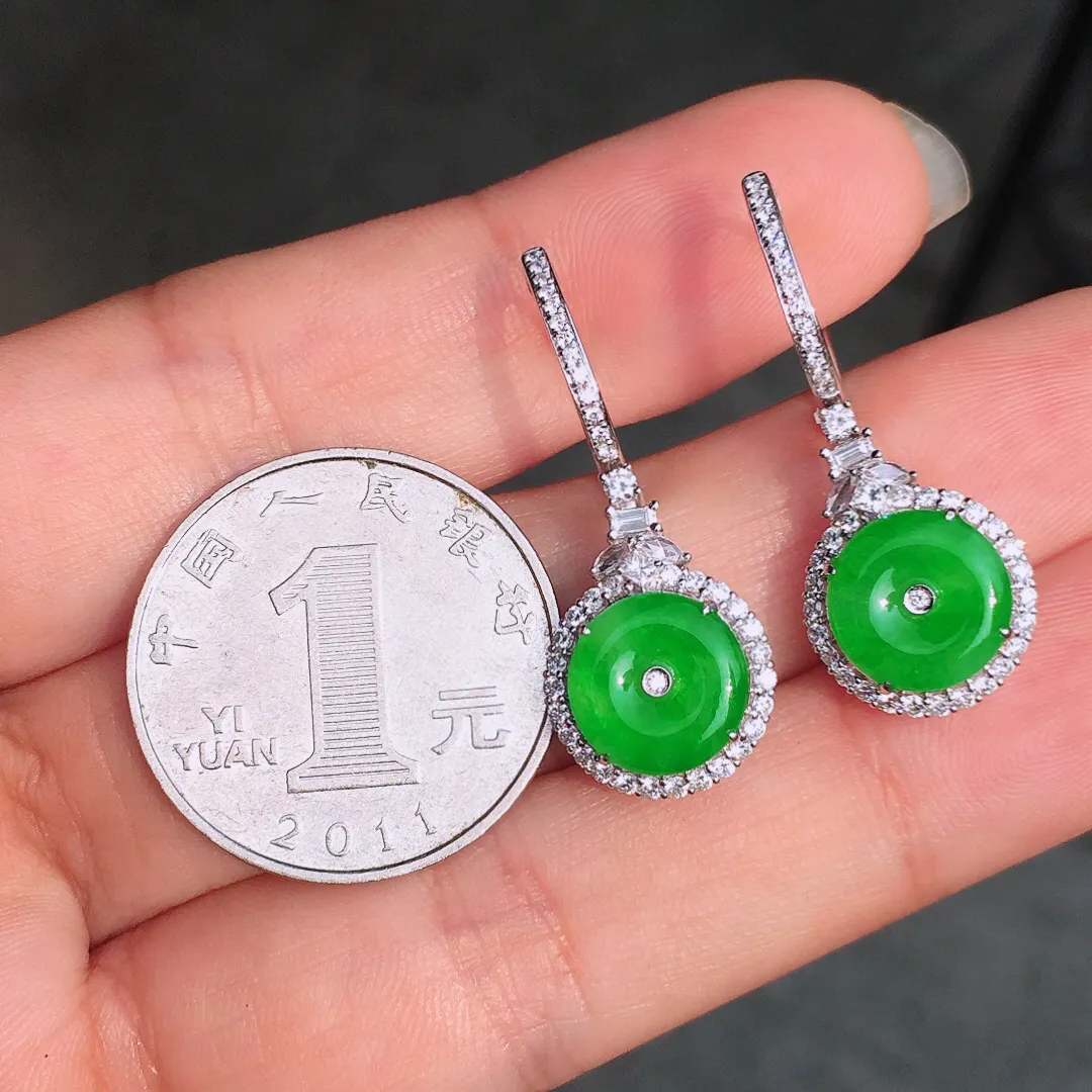 阳绿平安扣耳坠，色泽均匀艳丽，玉质细腻，荧光感超
强，饱满水润，气质满满。18k
金豪华镶嵌
