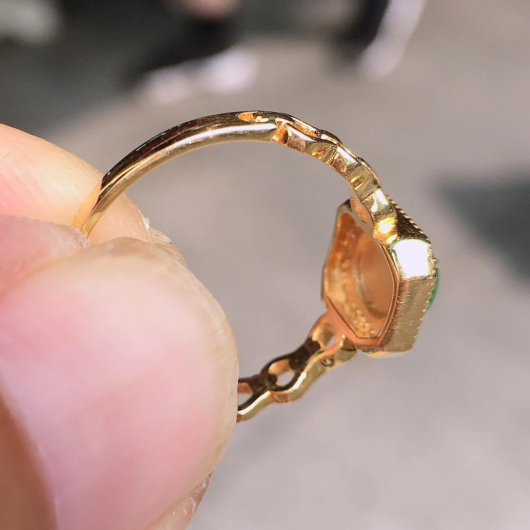 阳绿蛋面戒指，色泽均匀艳丽，玉质细腻，荧光感超
强，饱满水润，气质满满。18k
金豪华镶嵌