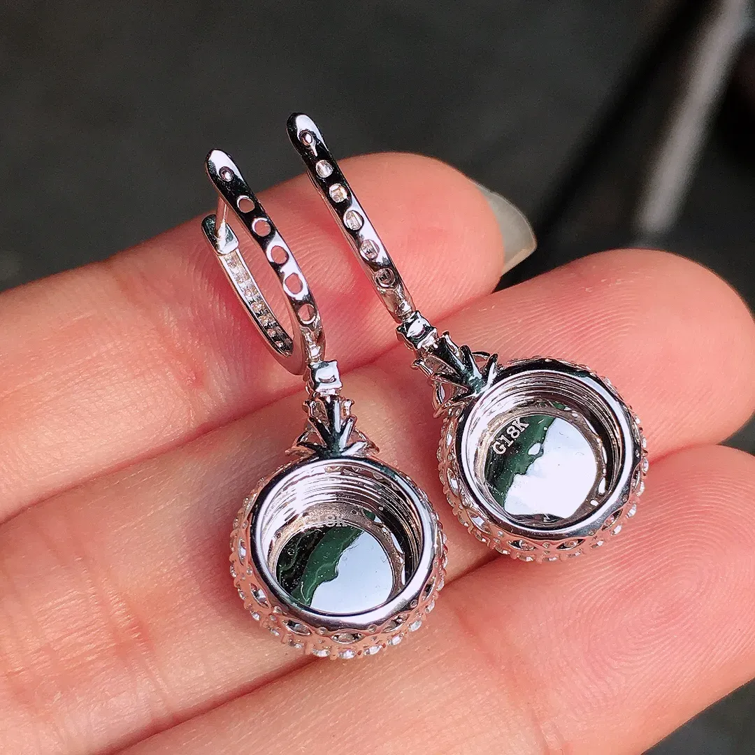 阳绿平安扣耳坠，色泽均匀艳丽，玉质细腻，荧光感超
强，饱满水润，气质满满。18k
金豪华镶嵌