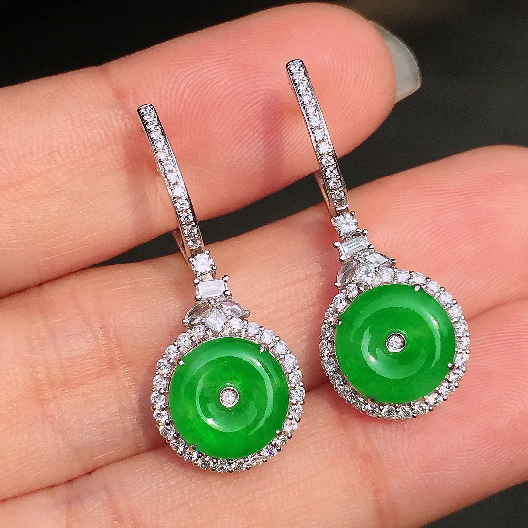 阳绿平安扣耳坠，色泽均匀艳丽，玉质细腻，荧光感超
强，饱满水润，气质满满。18k
金豪华镶嵌