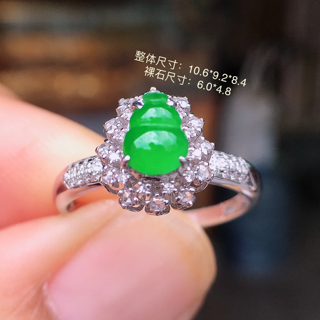 阳绿葫芦戒指，色泽均匀艳丽，玉质细腻，荧光感超
强，饱满水润，气质满满。18k
金豪华镶嵌