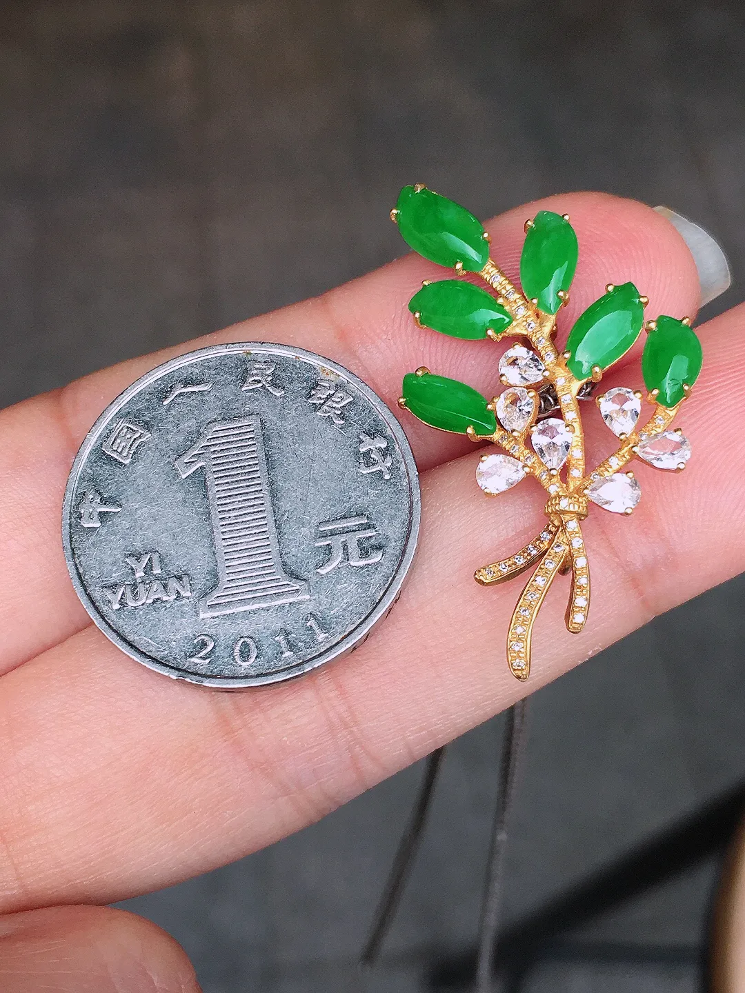阳绿胸针，色泽均匀艳丽，玉质细腻，荧光感超
强，饱满水润，气质满满。18k
金豪华镶嵌
