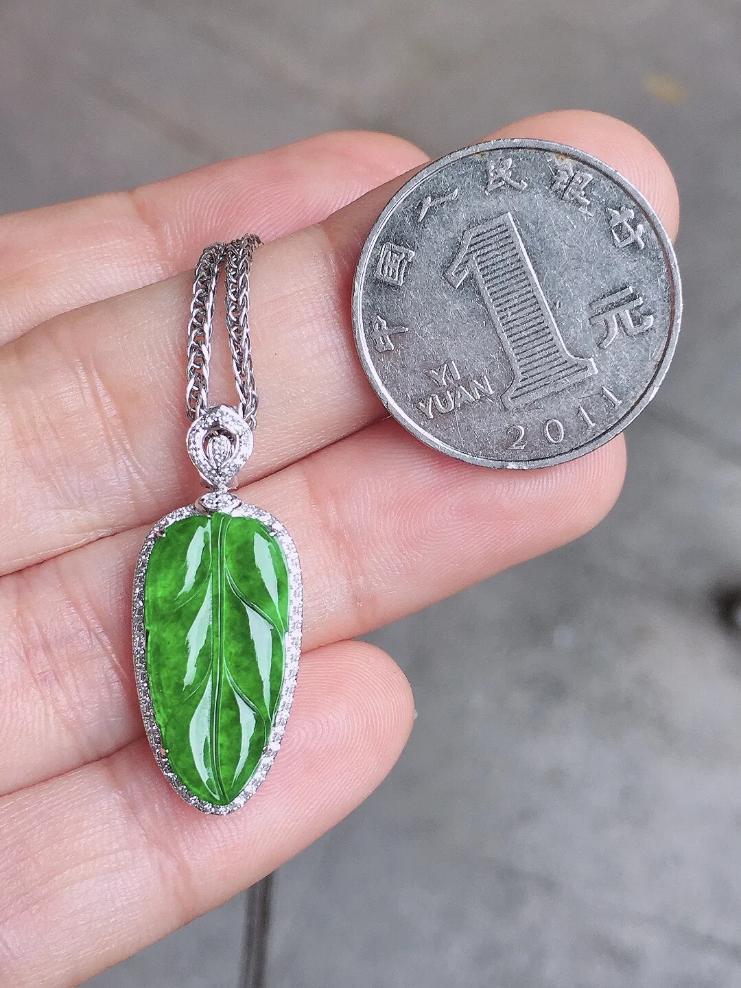 阳绿玉叶吊坠，色泽均匀艳丽，玉质细腻，荧光感超
强，饱满水润，气质满满。18k
金豪华镶嵌