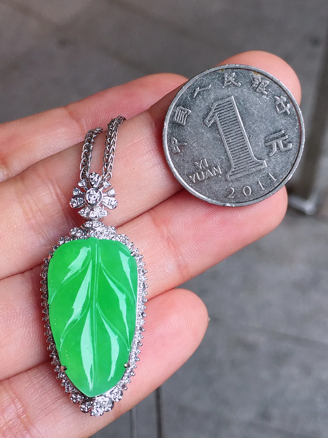 阳绿玉叶吊坠，色泽均匀艳丽，玉质细腻，荧光感超
强，饱满水润，气质满满。18k
金豪华镶嵌
