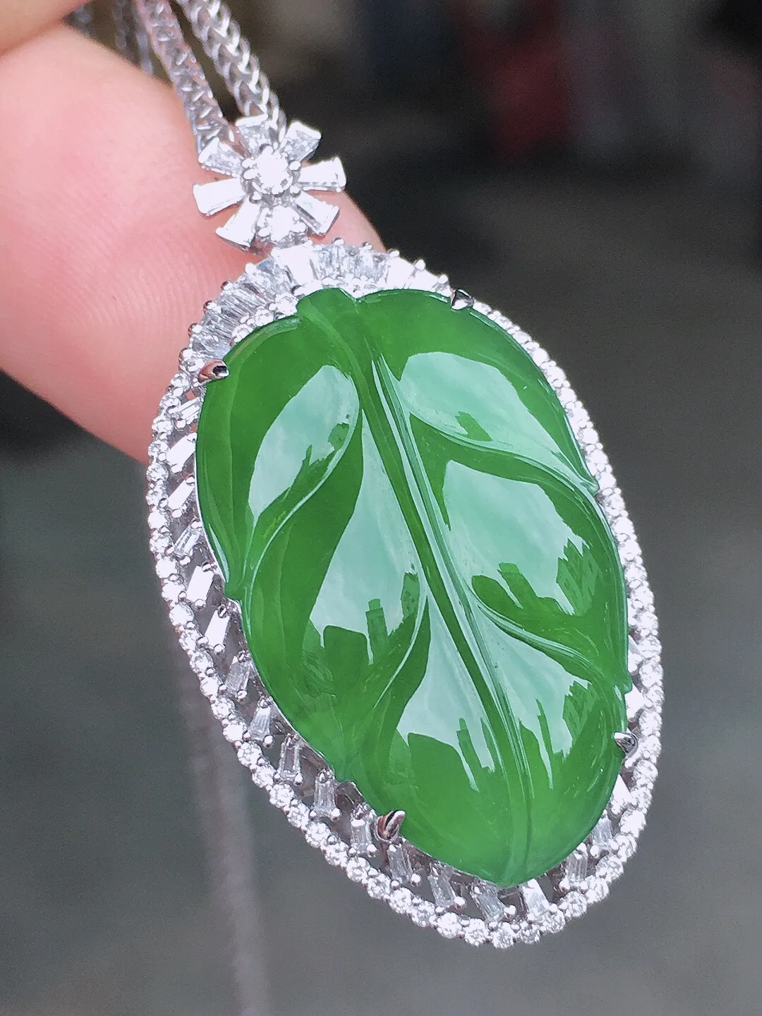 阳绿玉叶吊坠，色泽均匀艳丽，玉质细腻，荧光感超
强，饱满水润，气质满满。18k
金豪华镶嵌