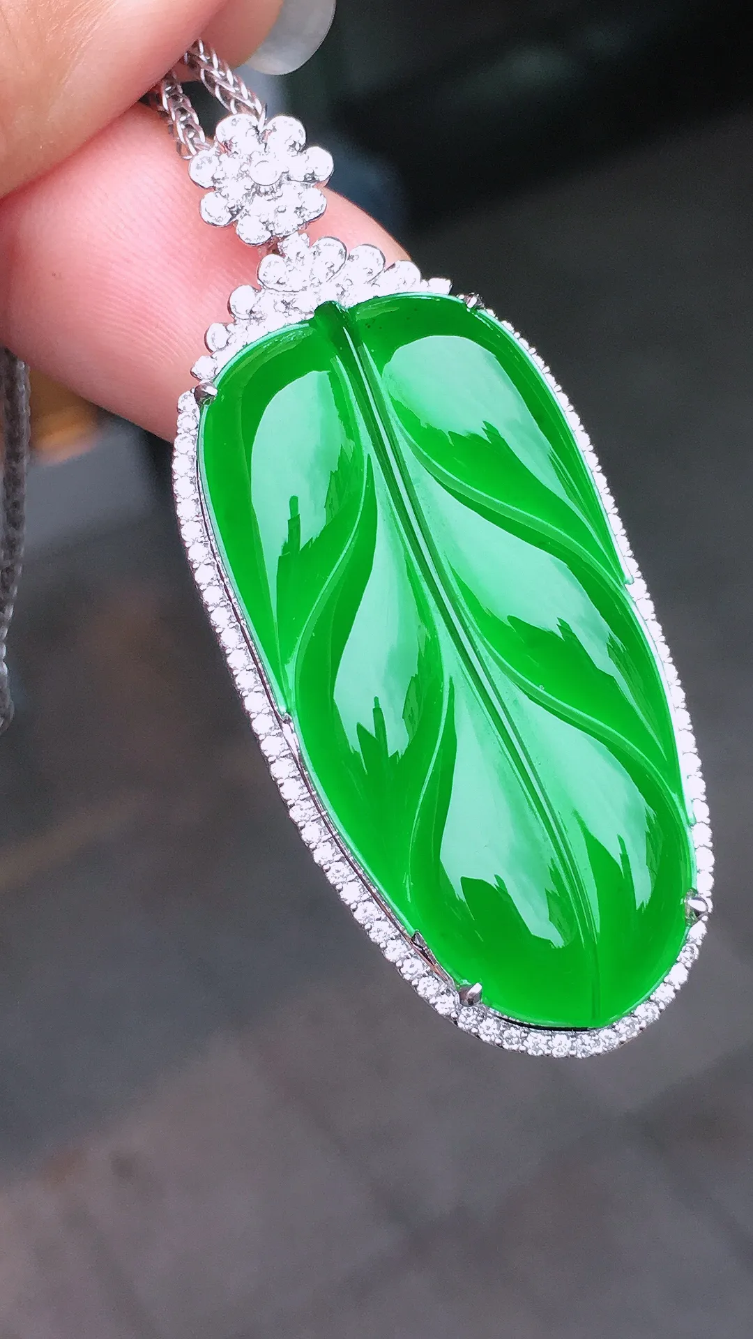 阳绿玉叶吊坠，色泽均匀艳丽，玉质细腻，荧光感超
强，饱满水润，气质满满。18k
金豪华镶嵌