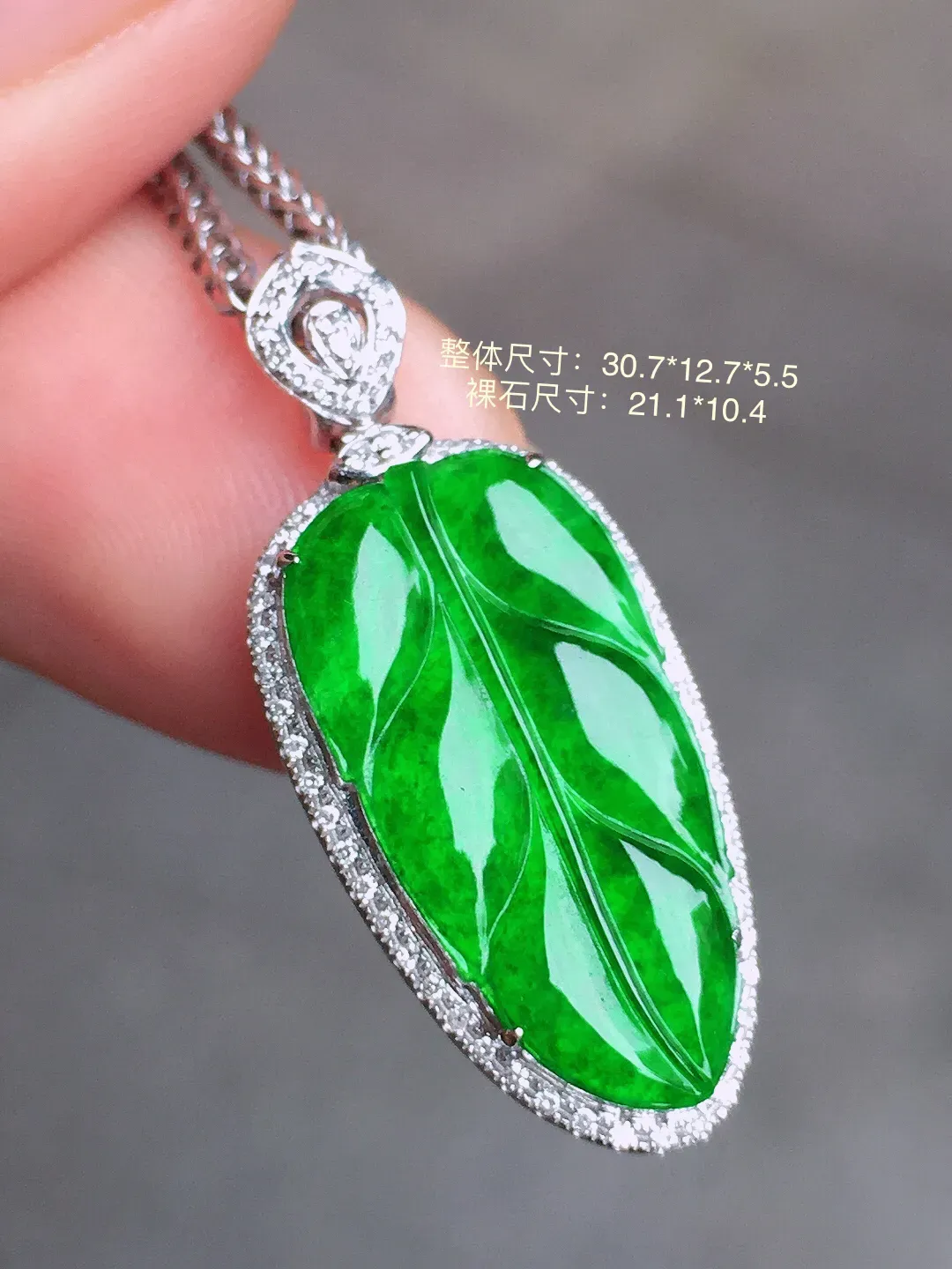 阳绿玉叶吊坠，色泽均匀艳丽，玉质细腻，荧光感超
强，饱满水润，气质满满。18k
金豪华镶嵌