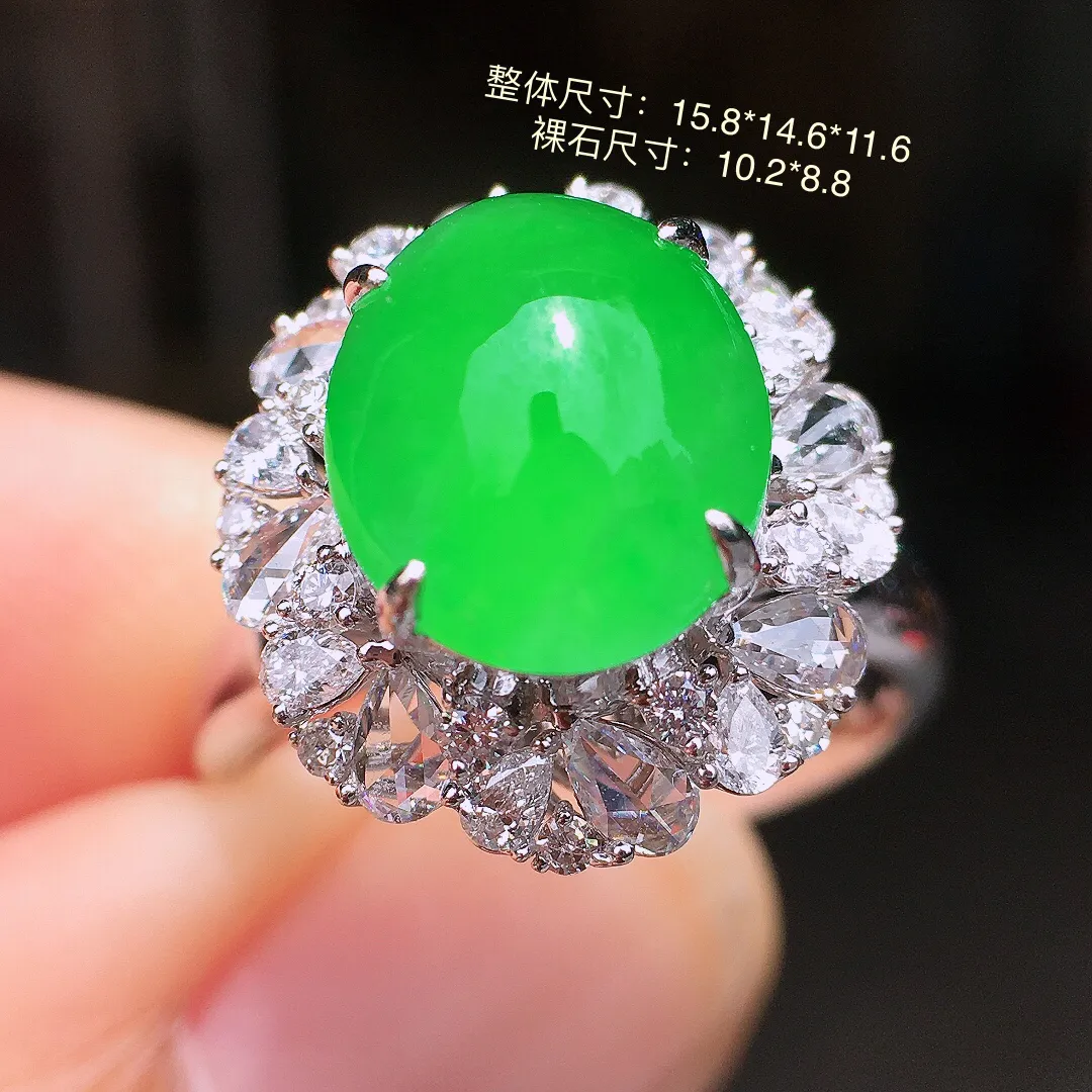 阳绿蛋面戒指，色泽均匀艳丽，玉质细腻，荧光感超
强，饱满水润，气质满满。18k
金豪华镶嵌