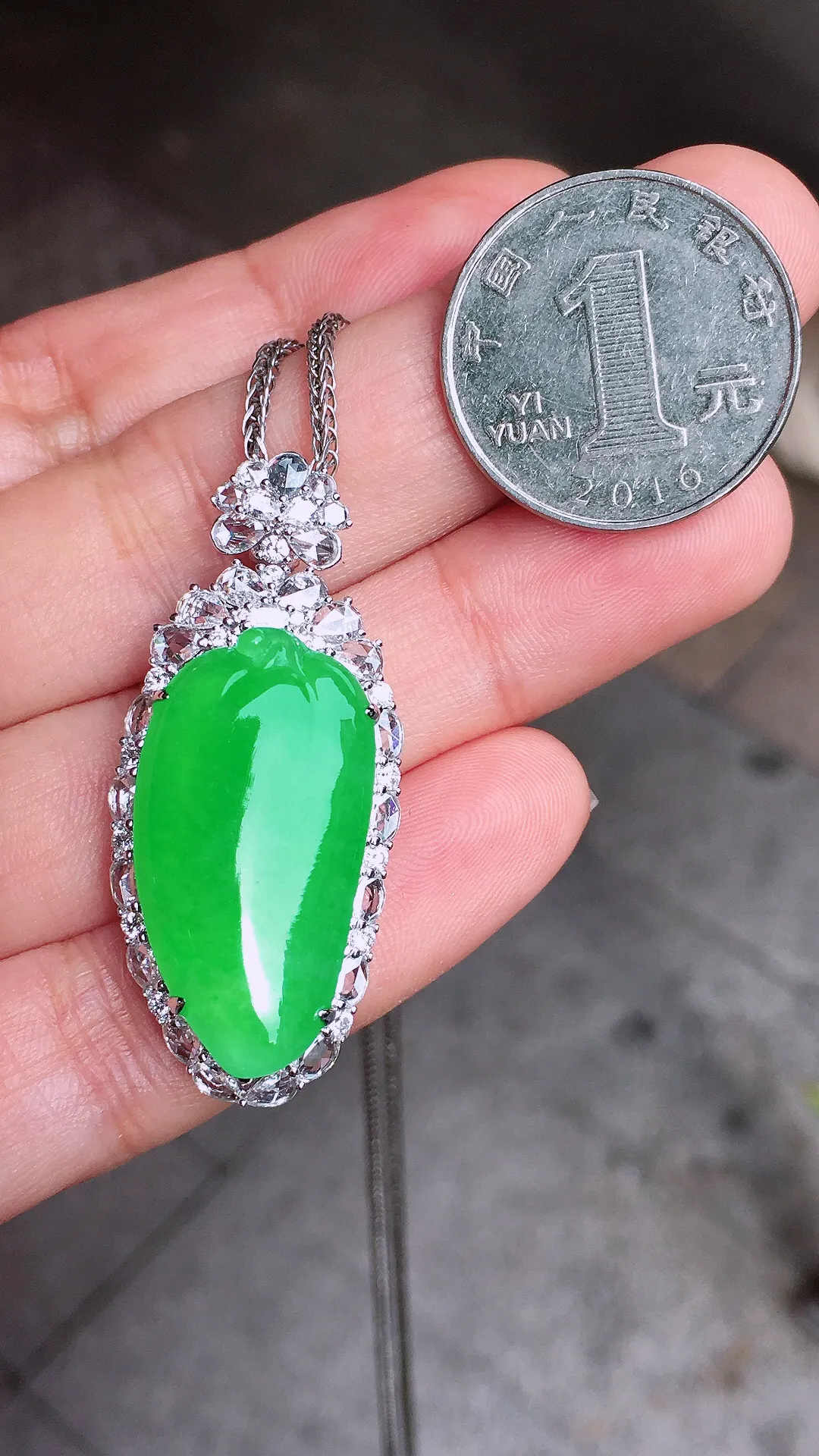 阳绿福瓜吊坠，色泽均匀艳丽，玉质细腻，荧光感超
强，饱满水润，气质满满。18k
金豪华镶嵌