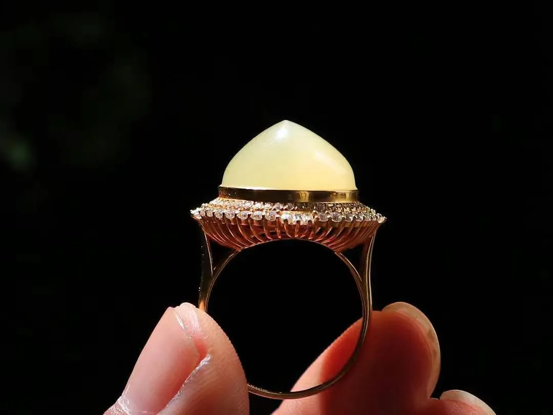 【金镶玉.戒指】

精品和田玉黄口18k金戒指 玉质细腻温润 油性十足 ，不论时光如何流转变化，这枚戒指始终闪耀着最初的光芒。精工镶嵌18K金 （保真金 可检测贵金属18K金） 重7.8克 尺寸17.6-14.7mm 78402455L