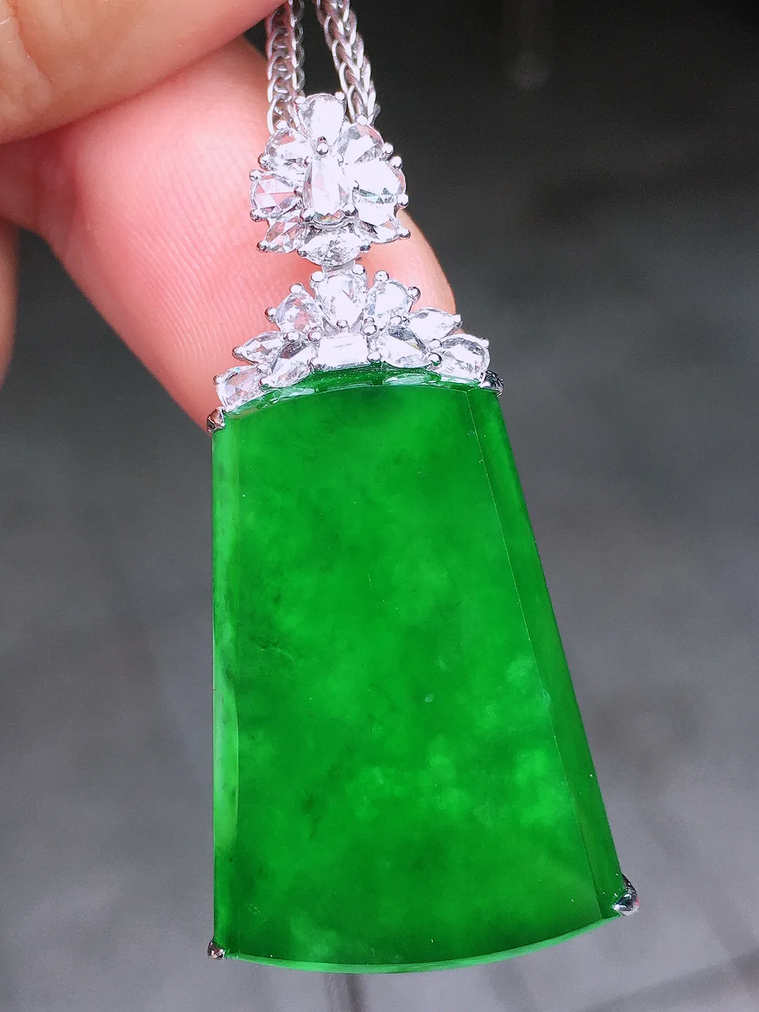 阳绿无事牌吊坠，色泽均匀艳丽，玉质细腻，荧光感超
强，饱满水润，气质满满。18k
金豪华镶嵌