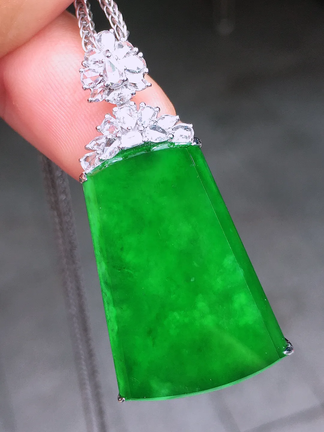 阳绿无事牌吊坠，色泽均匀艳丽，玉质细腻，荧光感超
强，饱满水润，气质满满。18k
金豪华镶嵌