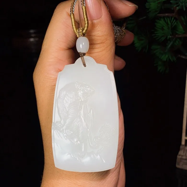 新疆且末料羊脂白玉下山虎牌子挂件。“上山虎升官，下山虎发财”尺寸61/36/12mm重56克 白度一级。玉质细腻油润。手推出油。品相大气 lt250519