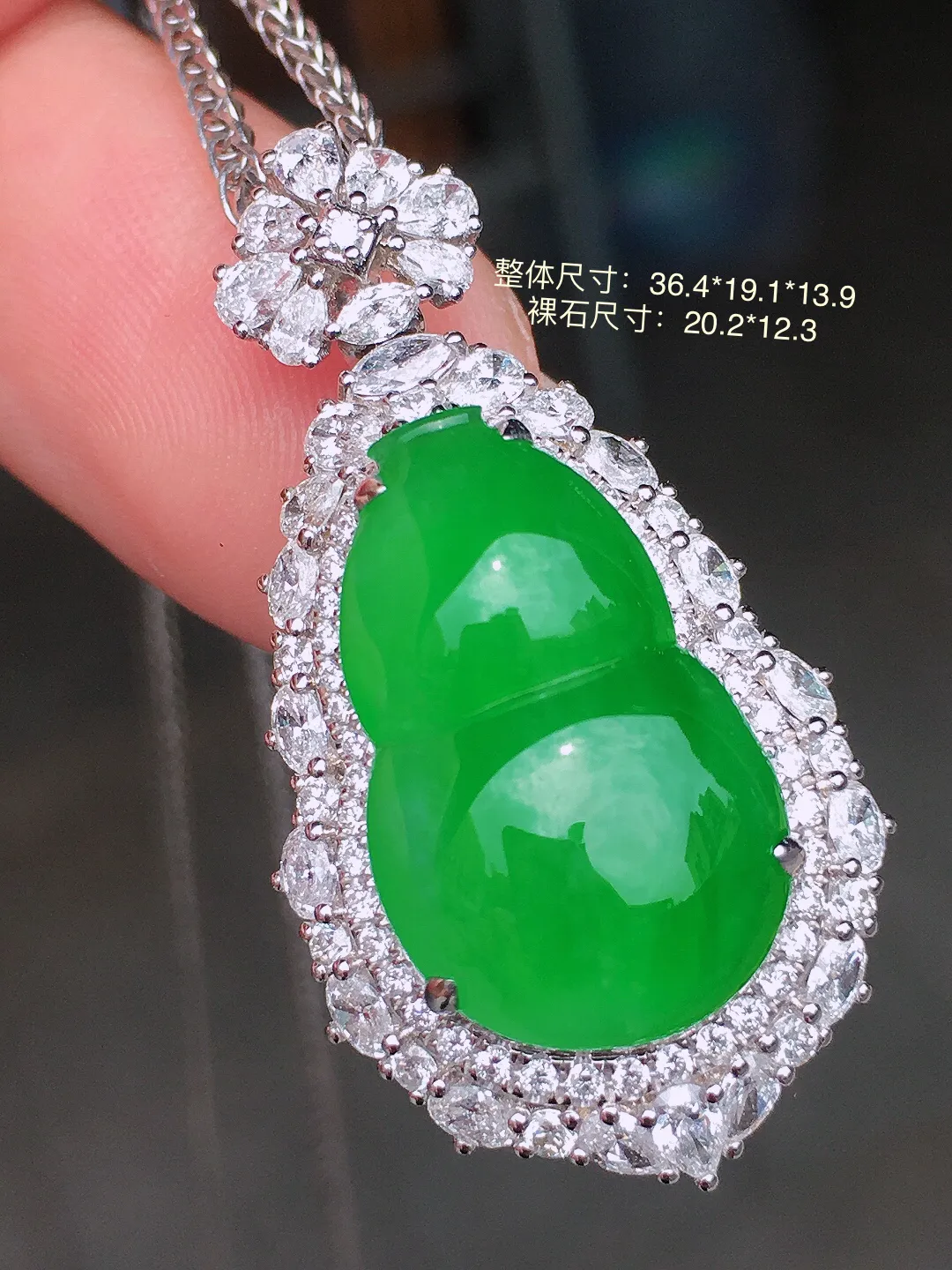 阳绿葫芦吊坠，色泽均匀艳丽，玉质细腻，荧光感超
强，饱满水润，气质满满。18k
金豪华镶嵌