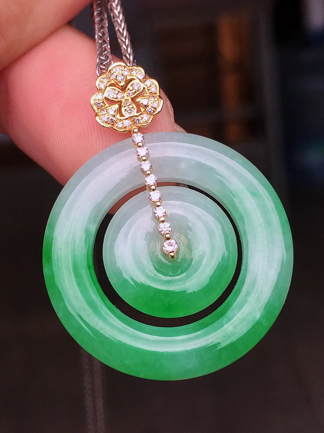 阳绿母子扣吊坠，色泽艳丽，玉质细腻，荧光感超
强，饱满水润，气质满满。18k
金豪华镶嵌
