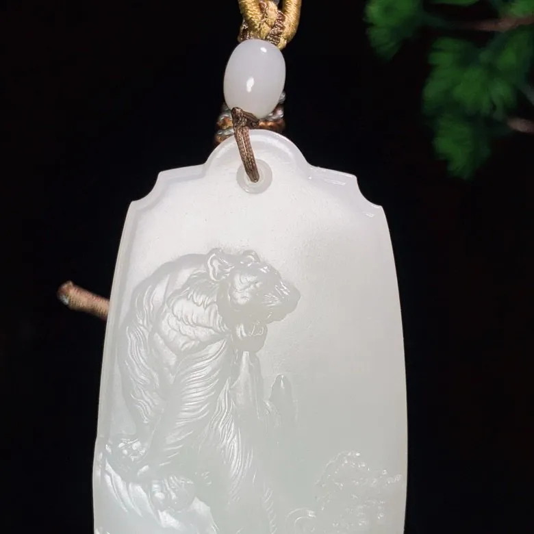 新疆且末料羊脂白玉下山虎牌子挂件。“上山虎升官，下山虎发财”尺寸61/36/12mm重56克 白度一级。玉质细腻油润。手推出油。品相大气 lt250519