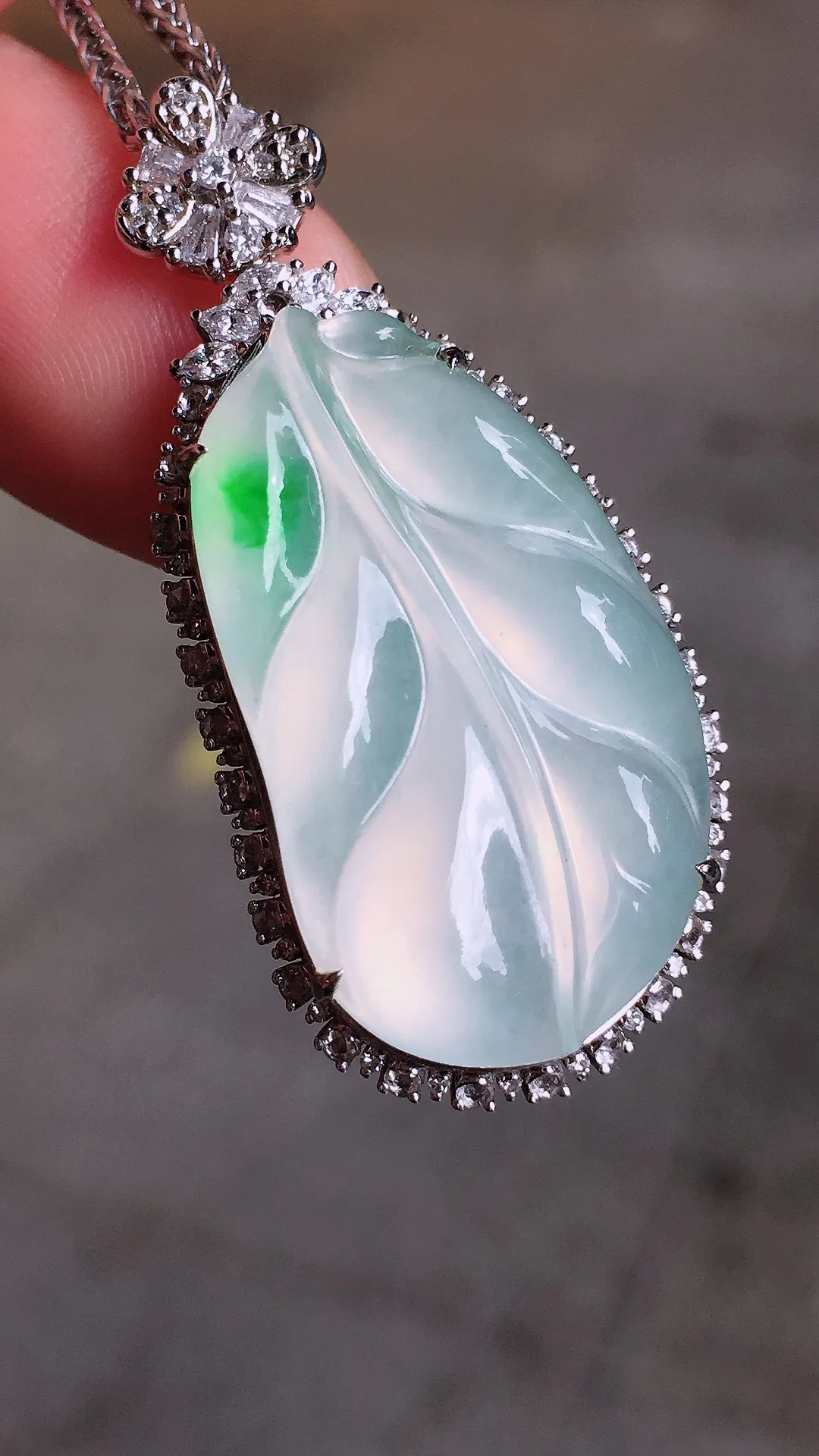 飘绿玉叶吊坠，色泽艳丽，玉质细腻，荧光感超
强，饱满水润，气质满满。18k
金豪华镶嵌