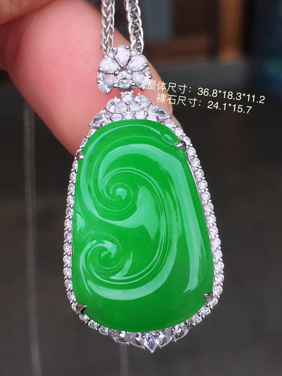 阳绿如意吊坠，色泽均匀艳丽，玉质细腻，荧光感超
强，饱满水润，气质满满。18k
金豪华镶嵌