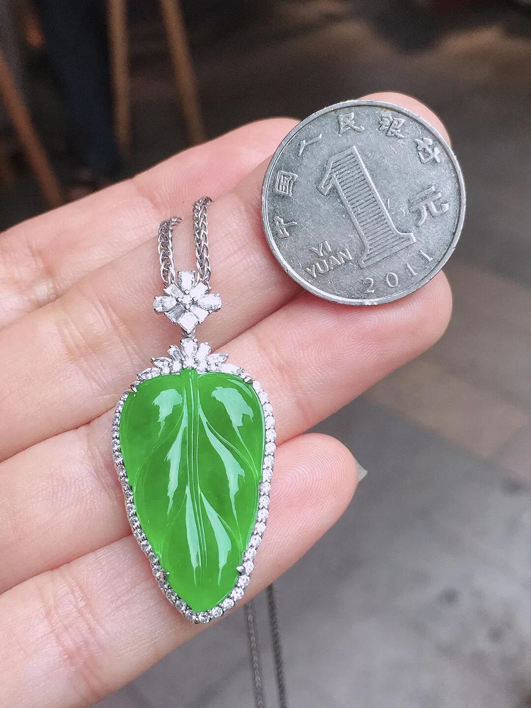 阳绿玉叶吊坠，色泽均匀艳丽，玉质细腻，荧光感超
强，饱满水润，气质满满。18k
金豪华镶嵌