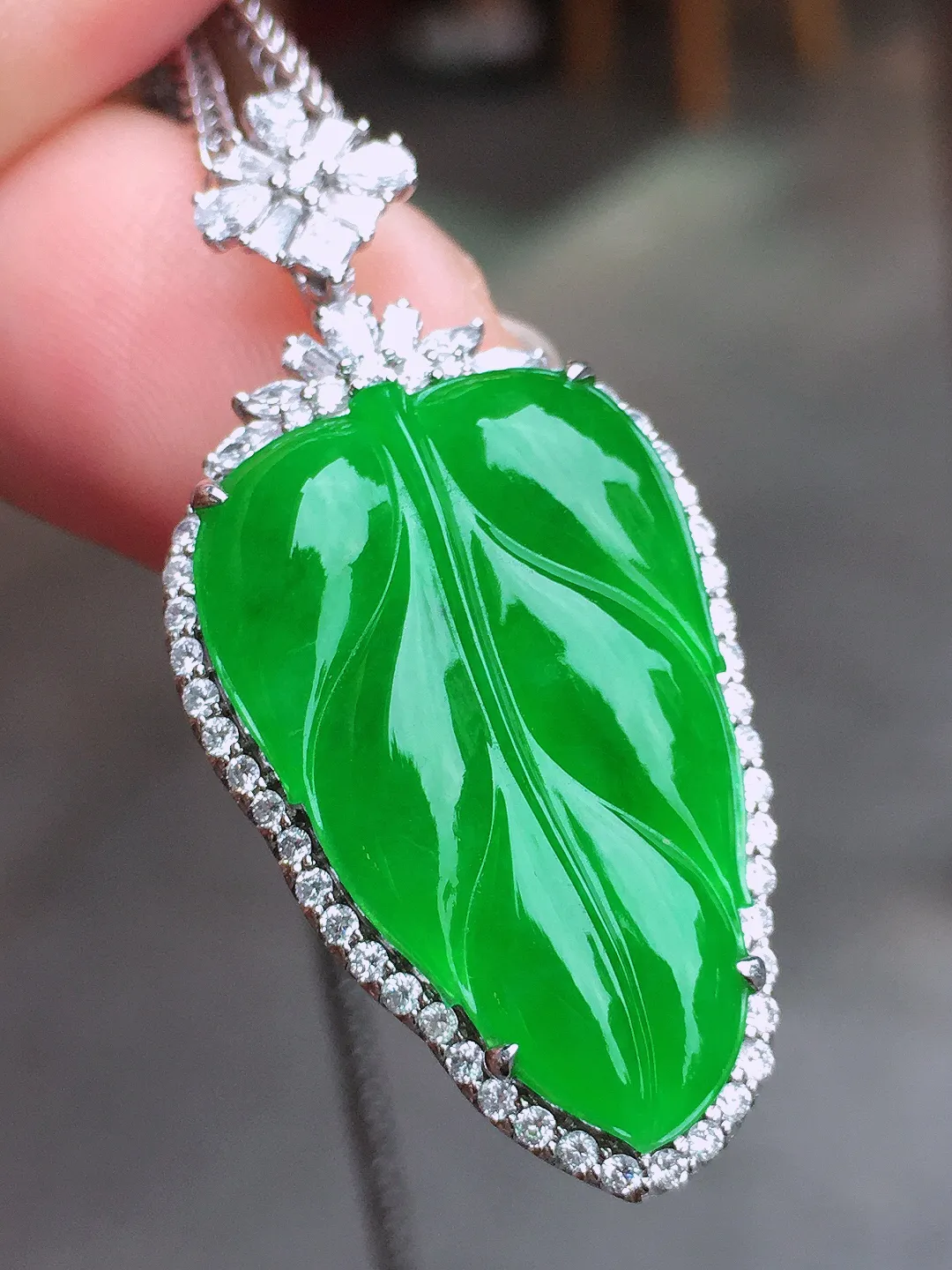 阳绿玉叶吊坠，色泽均匀艳丽，玉质细腻，荧光感超
强，饱满水润，气质满满。18k
金豪华镶嵌