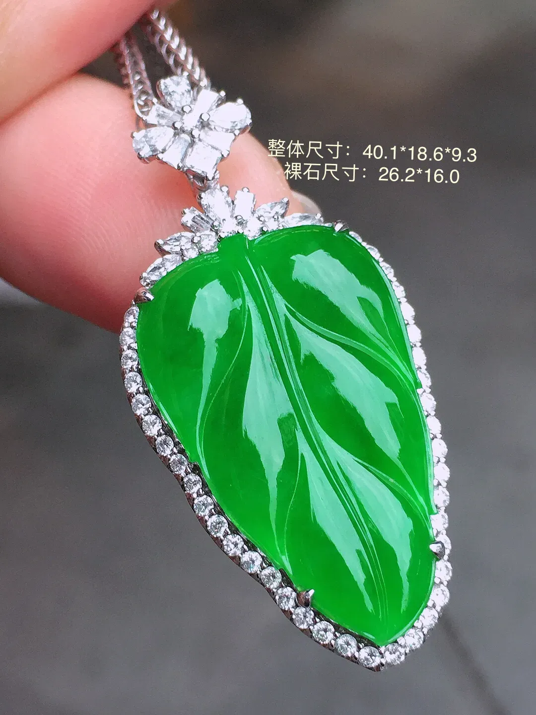 阳绿玉叶吊坠，色泽均匀艳丽，玉质细腻，荧光感超
强，饱满水润，气质满满。18k
金豪华镶嵌